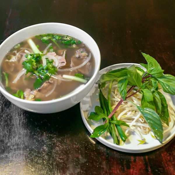 Phở Tái — beef eye round pho with a side plate of basil and bean sprouts